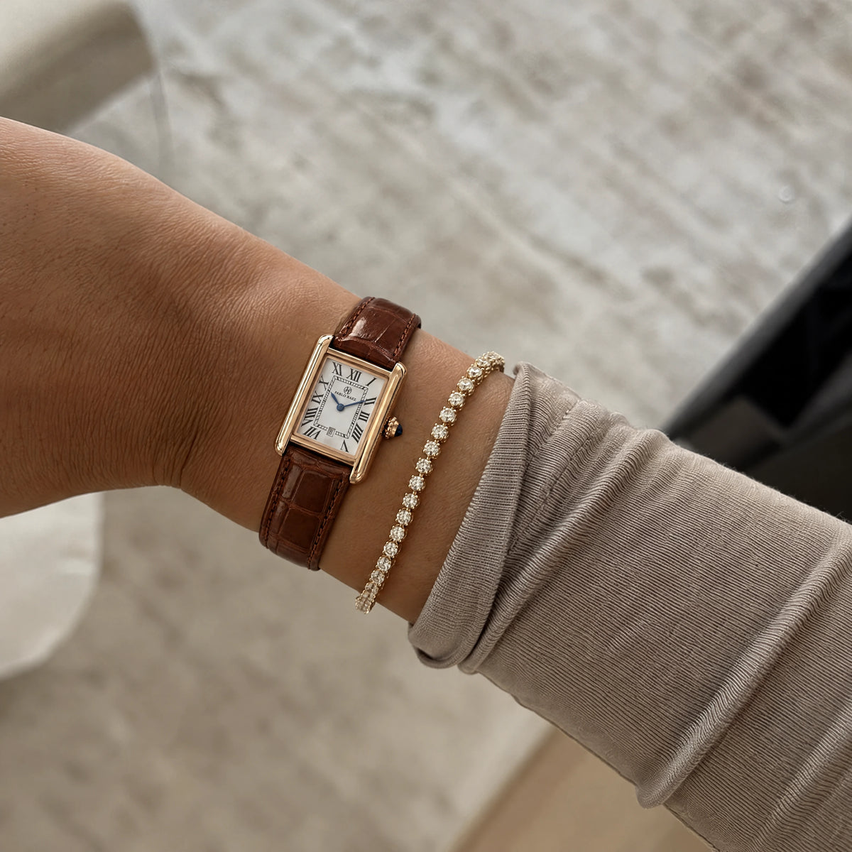 Houston Essence Gold 28mm worn on a woman's wrist with brown leather strap and layered bracelets #color_brown