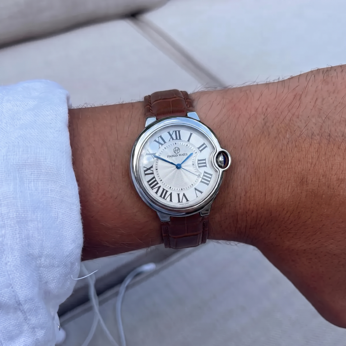 Murray 36mm watch with brown alligator leather strap on a man's wrist, worn with a white linen shirt cuff #color_brown