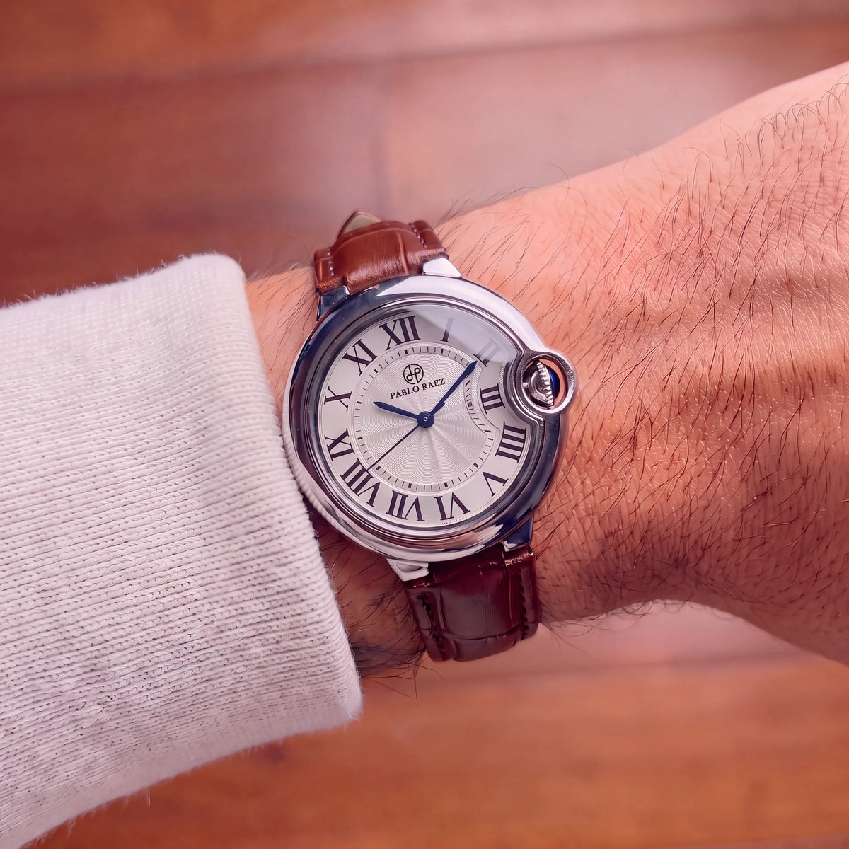 Murray 36mm silver watch with brown leather strap worn on a man's wrist, close-up of the white Roman numeral dial #color_brown