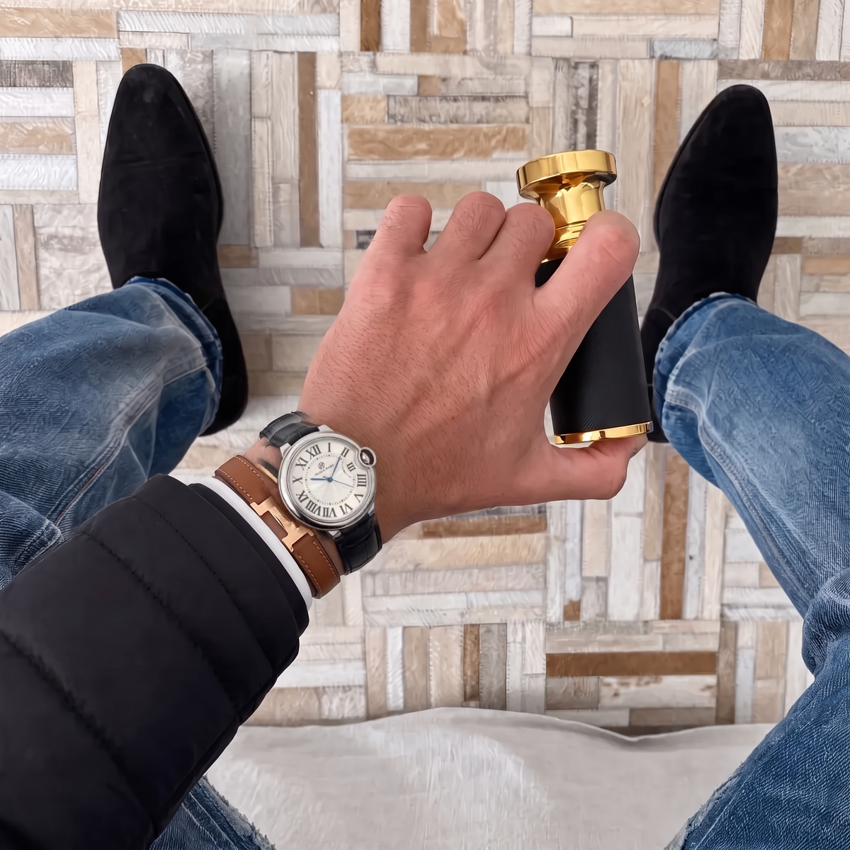 Murray 36mm watch with black leather strap worn beside leather bracelets on a man's wrist #color_black